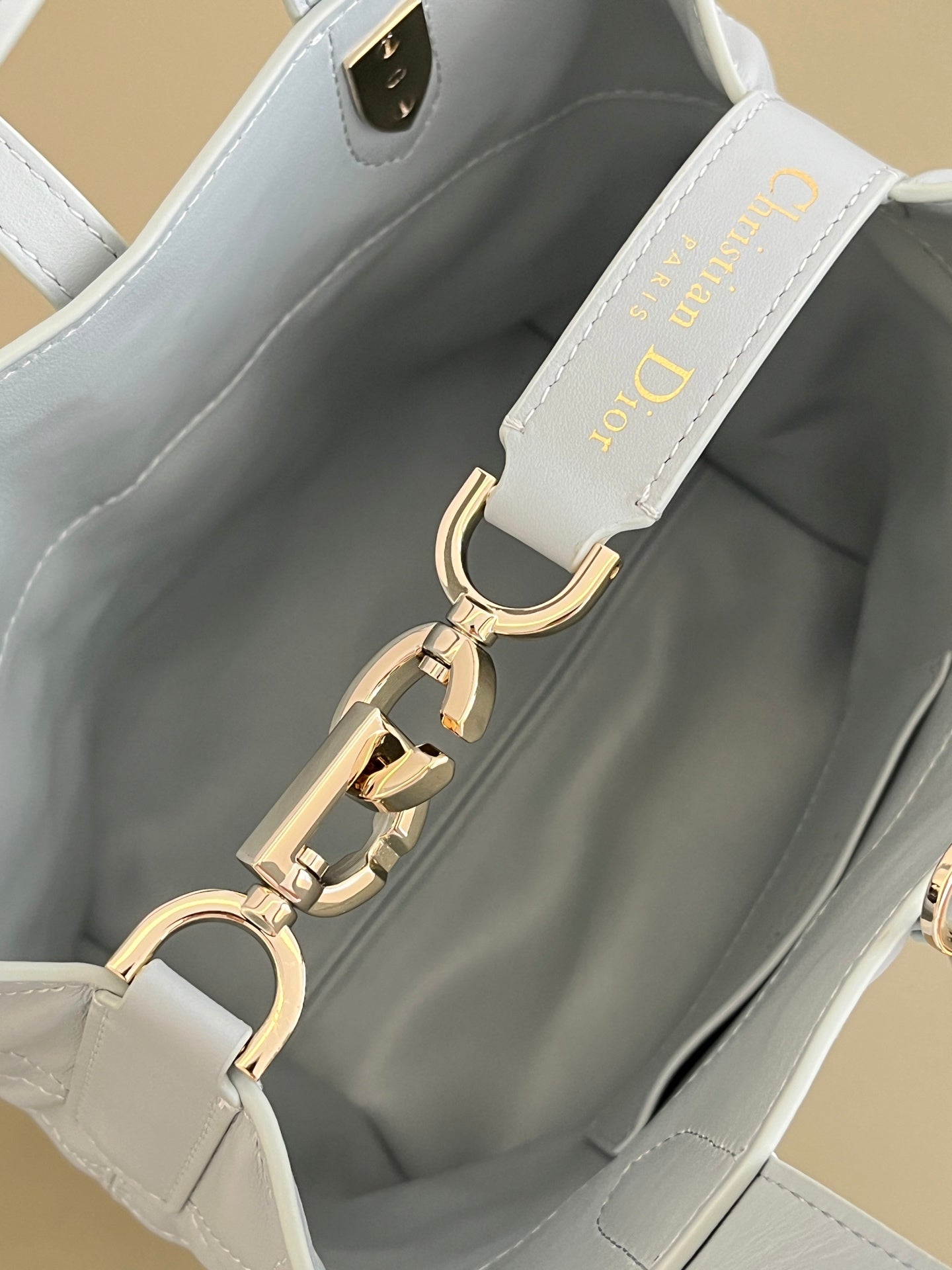 Dior light-blue handbag interior with lining, gold chain hardware, and front strap