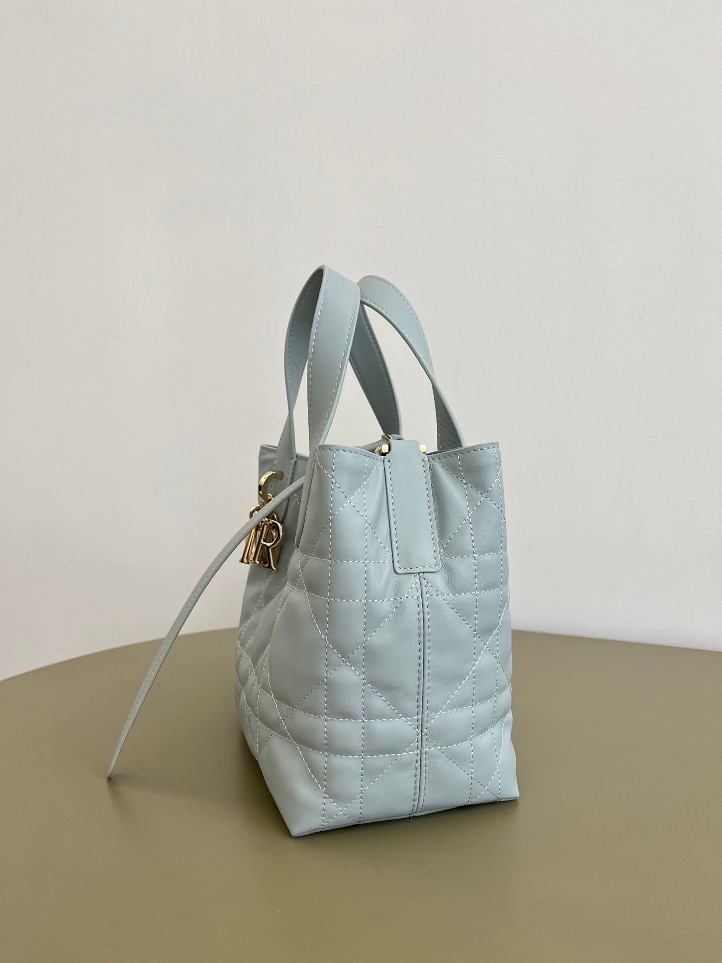 Dior light-blue quilted mini handbag with top handles and gold-tone clasp hardware