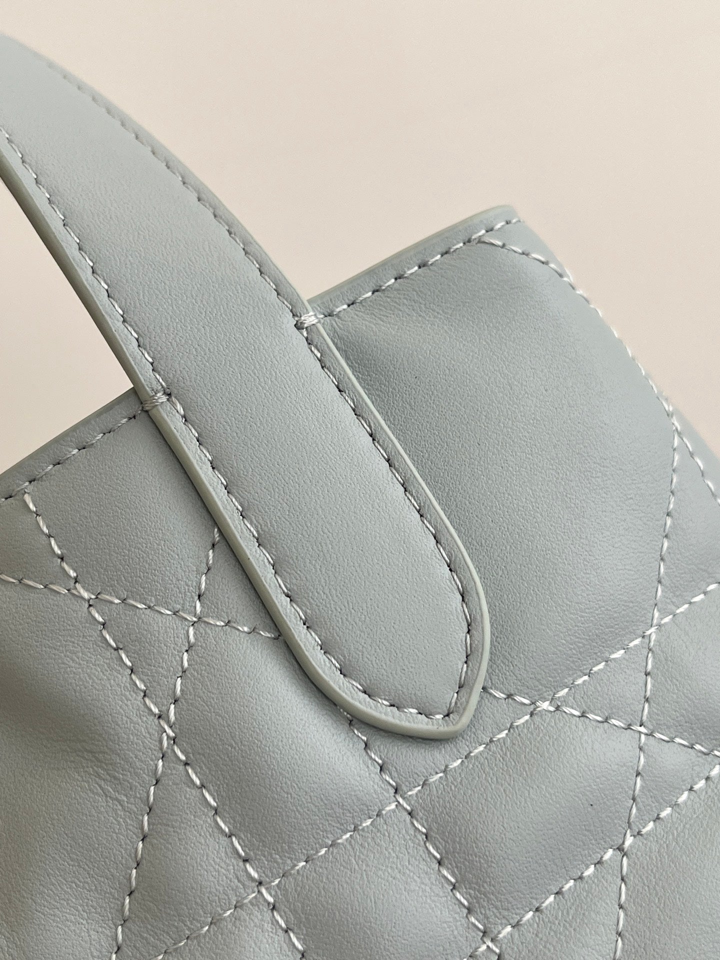 Dior light-blue quilted handbag front with stitched leather panel and handle loop