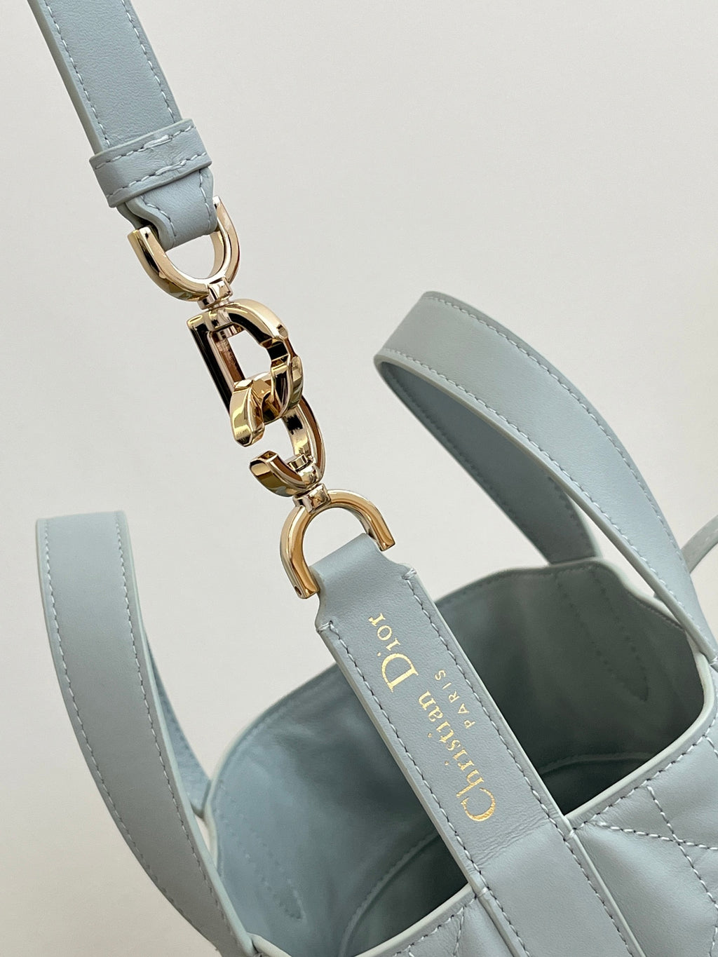 Dior light-blue shoulder strap with gold chain links and hardware clasp