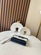 Chanel quilted mini bag with chain strap and gold clasp, black flap on white body