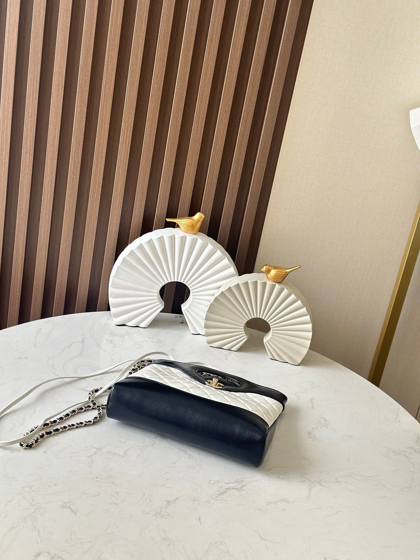 Chanel quilted mini bag with chain strap and gold clasp, black flap on white body