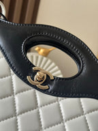 Chanel quilted handle detail with gold CC logo on black leather loop