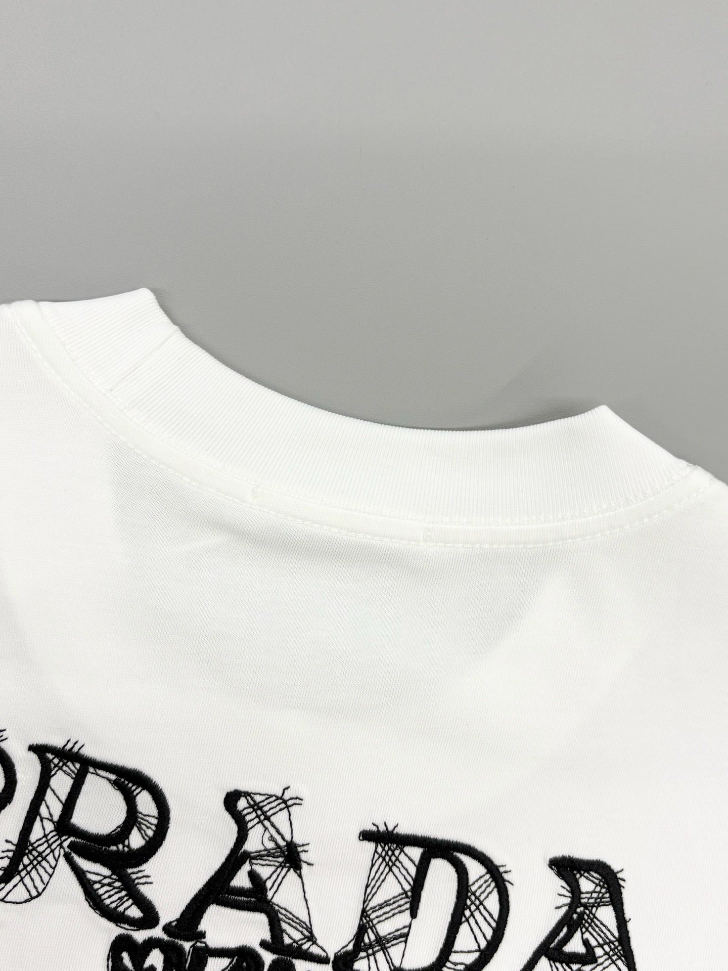Prada short-sleeve T-shirt collar with partial black PRADA lettering print
