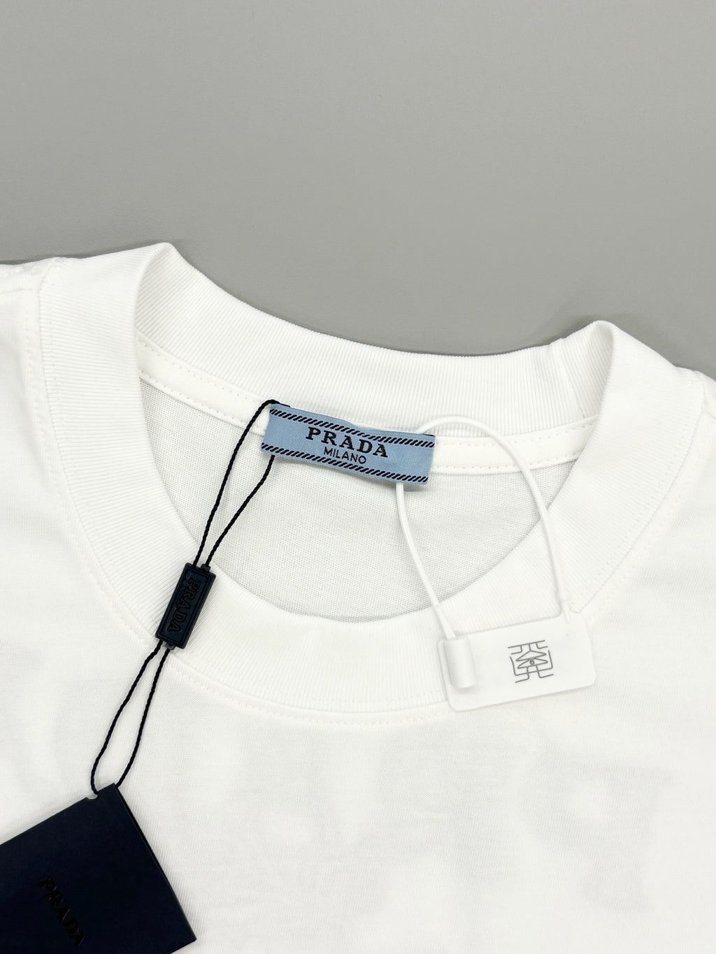 Prada short-sleeve T-shirt neckline with brand label and hanging price tag