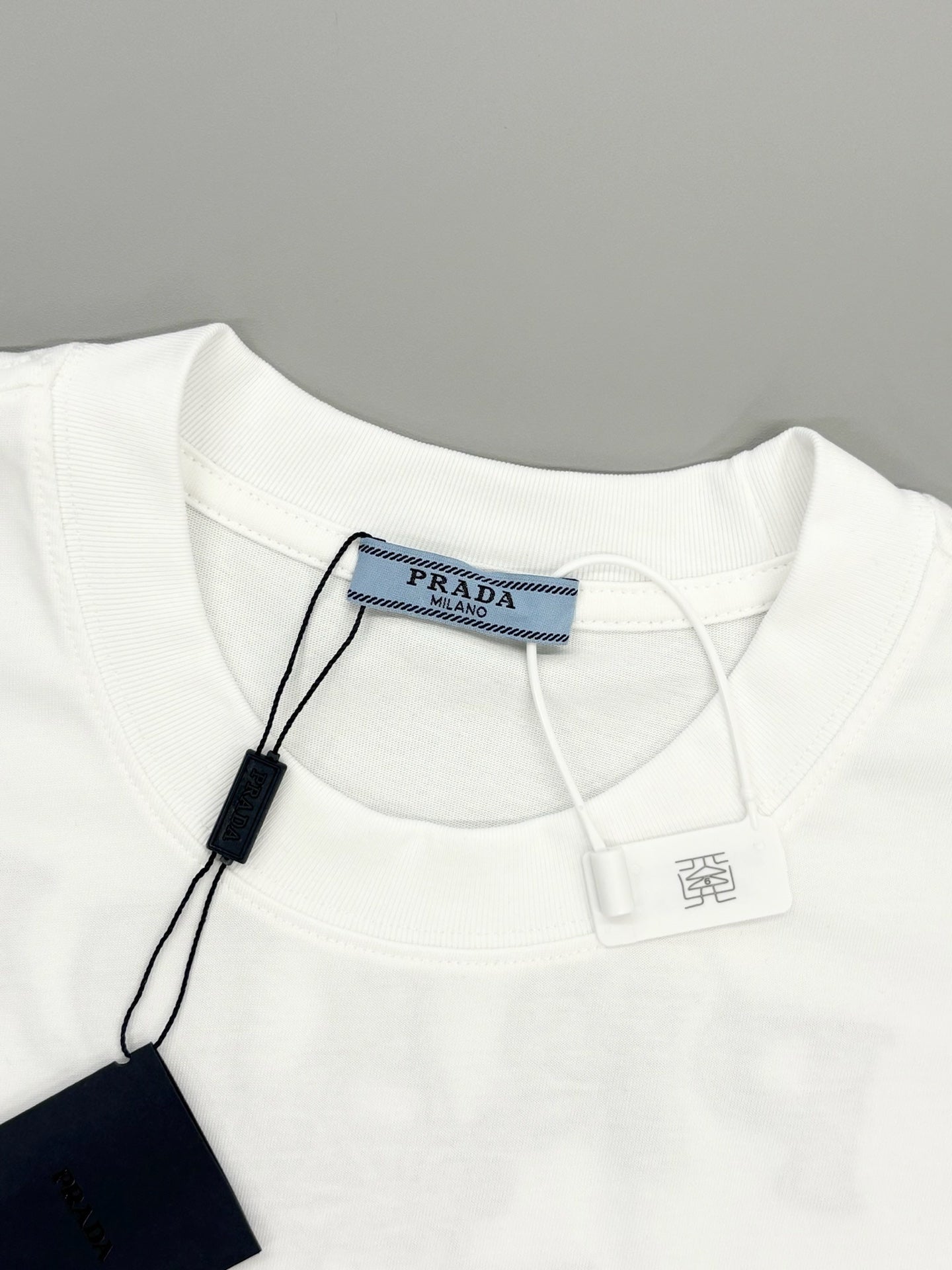 Prada short-sleeve T-shirt neckline with brand label and hanging price tag