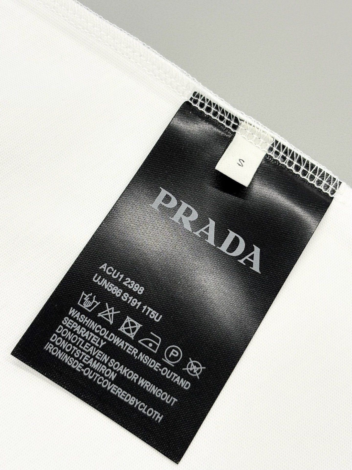 Prada care label inside white T-shirt with washing and material instructions