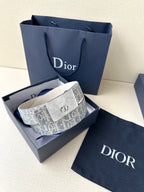 Dior belt with blue monogram strap and silver buckle, laid on box