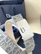 Dior belt close-up: blue monogram strap with silver D buckle and white strap