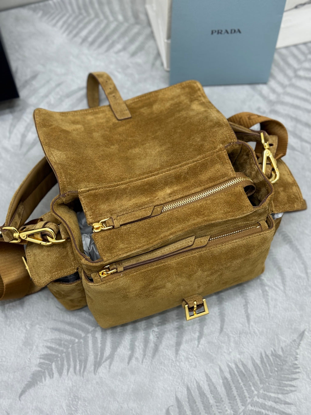 Prada suede mini bag open, showing zip pocket and interior lining