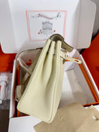 Cream leather handbag with top handles and adjustable shoulder strap, back view