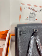 Hermes handbag front close-up in dark textured leather with flap details and hardware.