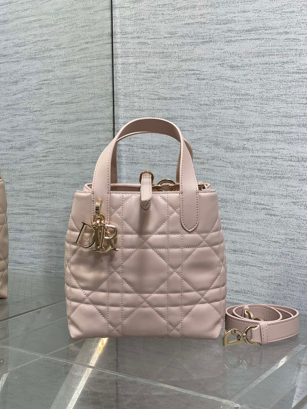 Quilted pale pink handbag with top handles and removable crossbody strap