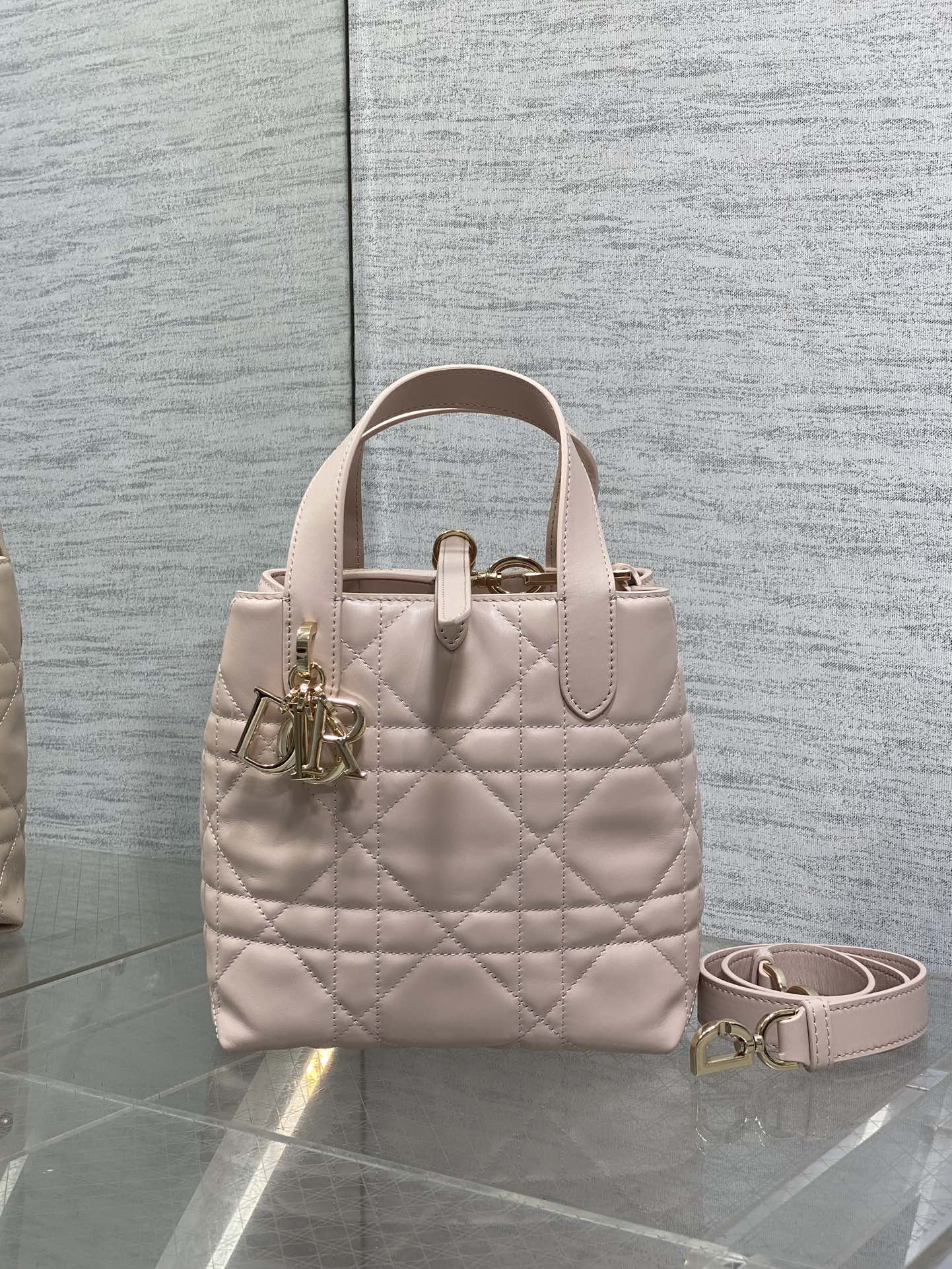 Quilted pale pink handbag with top handles and removable crossbody strap