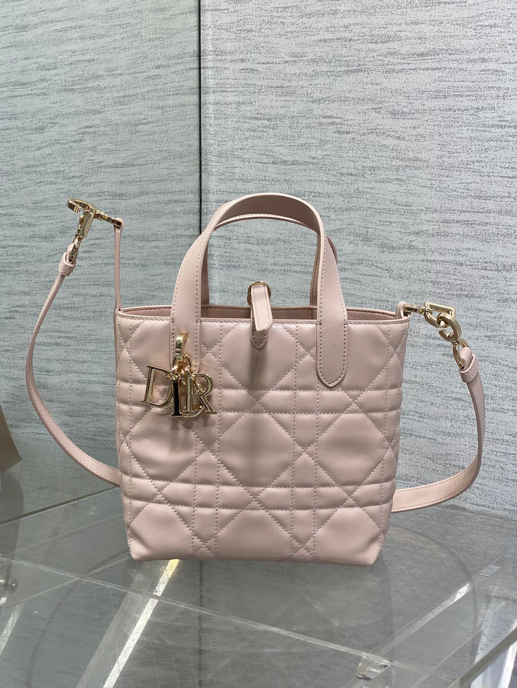 Quilted pale pink Dior handbag with top handles and side crossbody strap