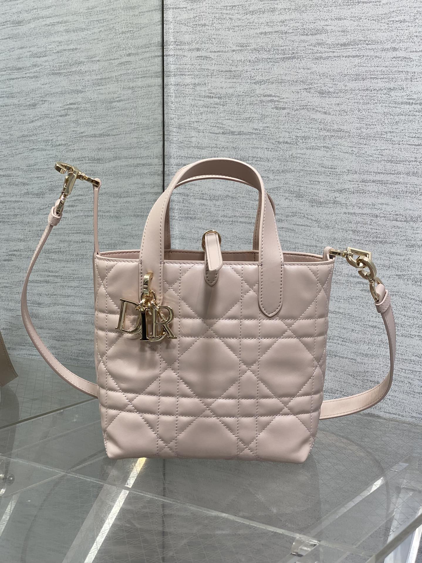 Quilted pale pink Dior handbag with top handles and side crossbody strap