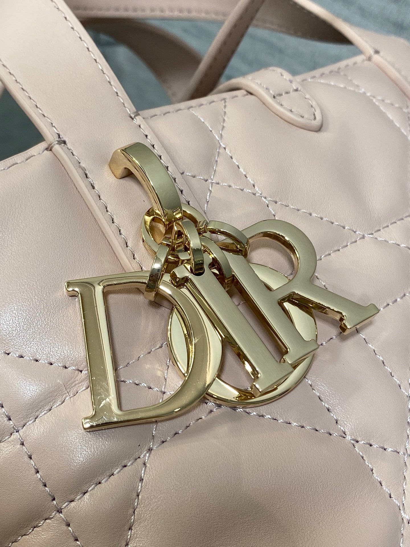 Gold Dior charms and hardware on quilted pale leather handbag