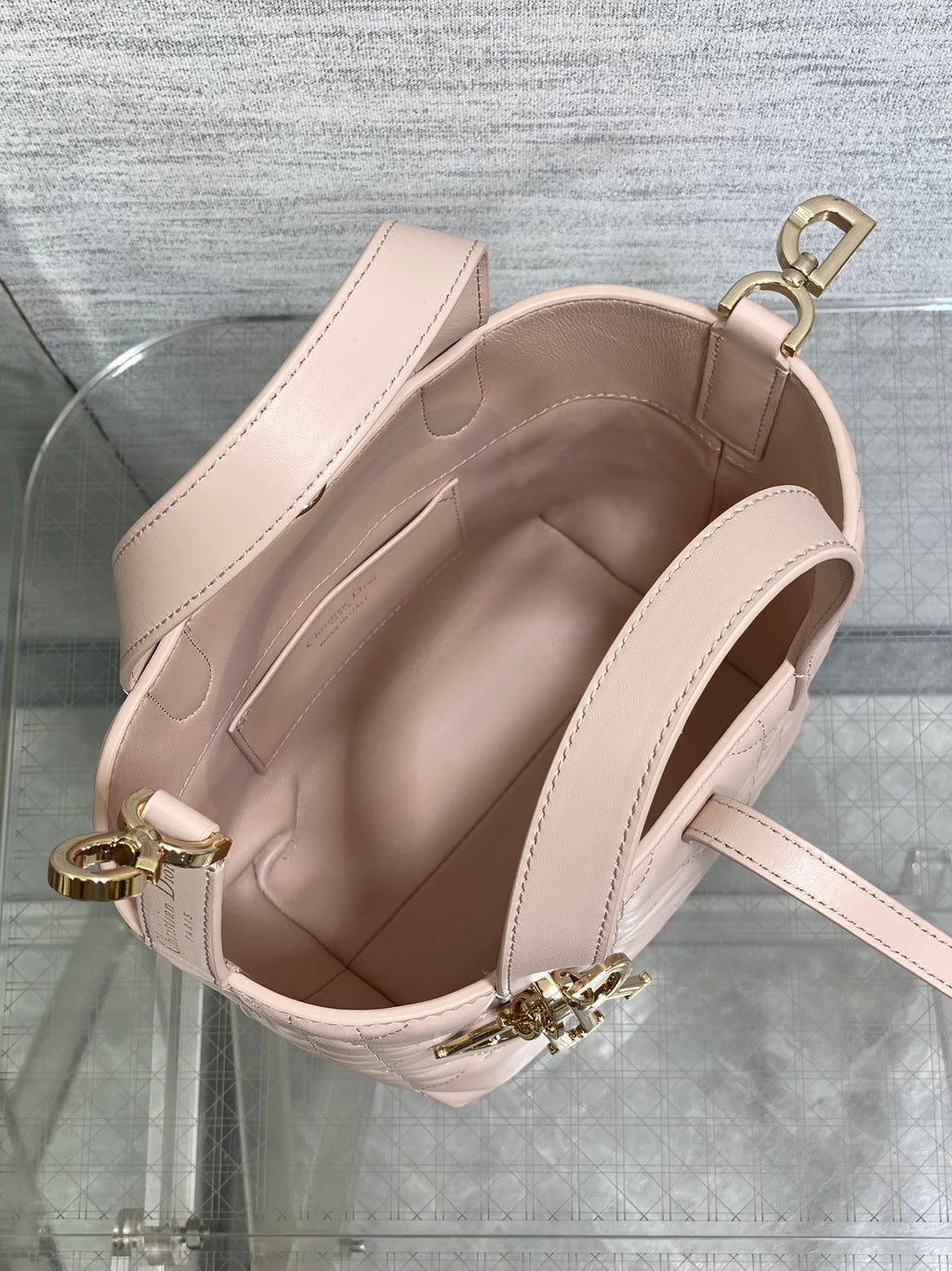 Open interior view of pale pink quilted handbag with top handle and strap