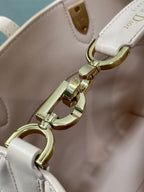 Gold clasp and ring hardware on pale pink handbag crossbody strap