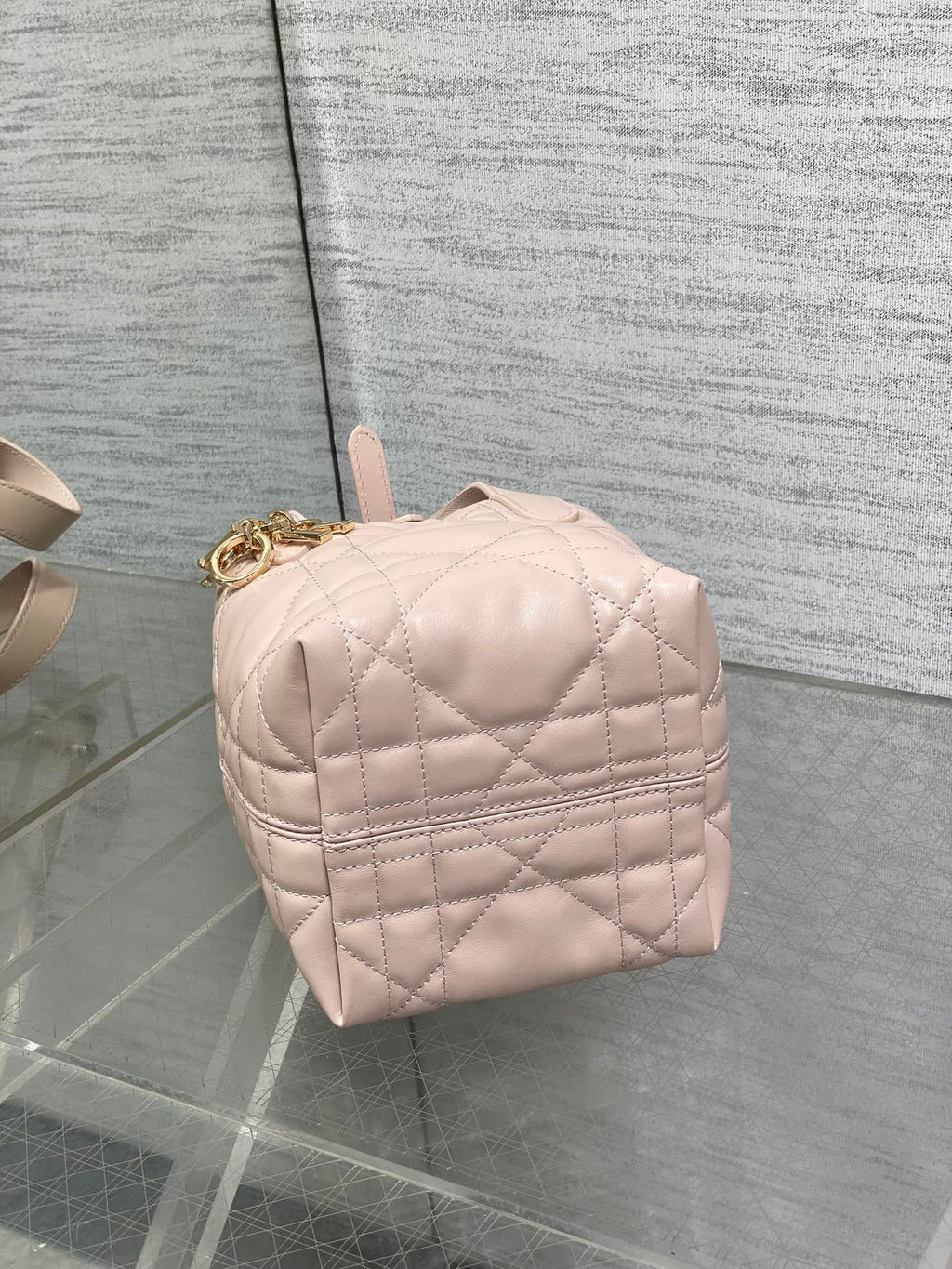 Dior quilted mini handbag back view in light pink with top handle and gold hardware