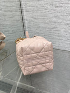 Dior quilted mini handbag back view in light pink with top handle and gold hardware