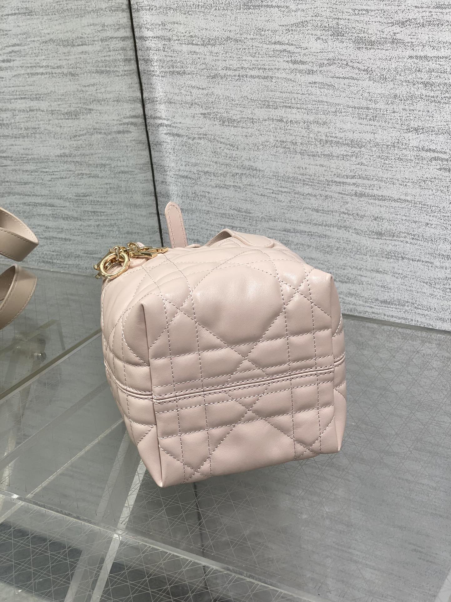 Dior quilted mini handbag back view in light pink with top handle and gold hardware