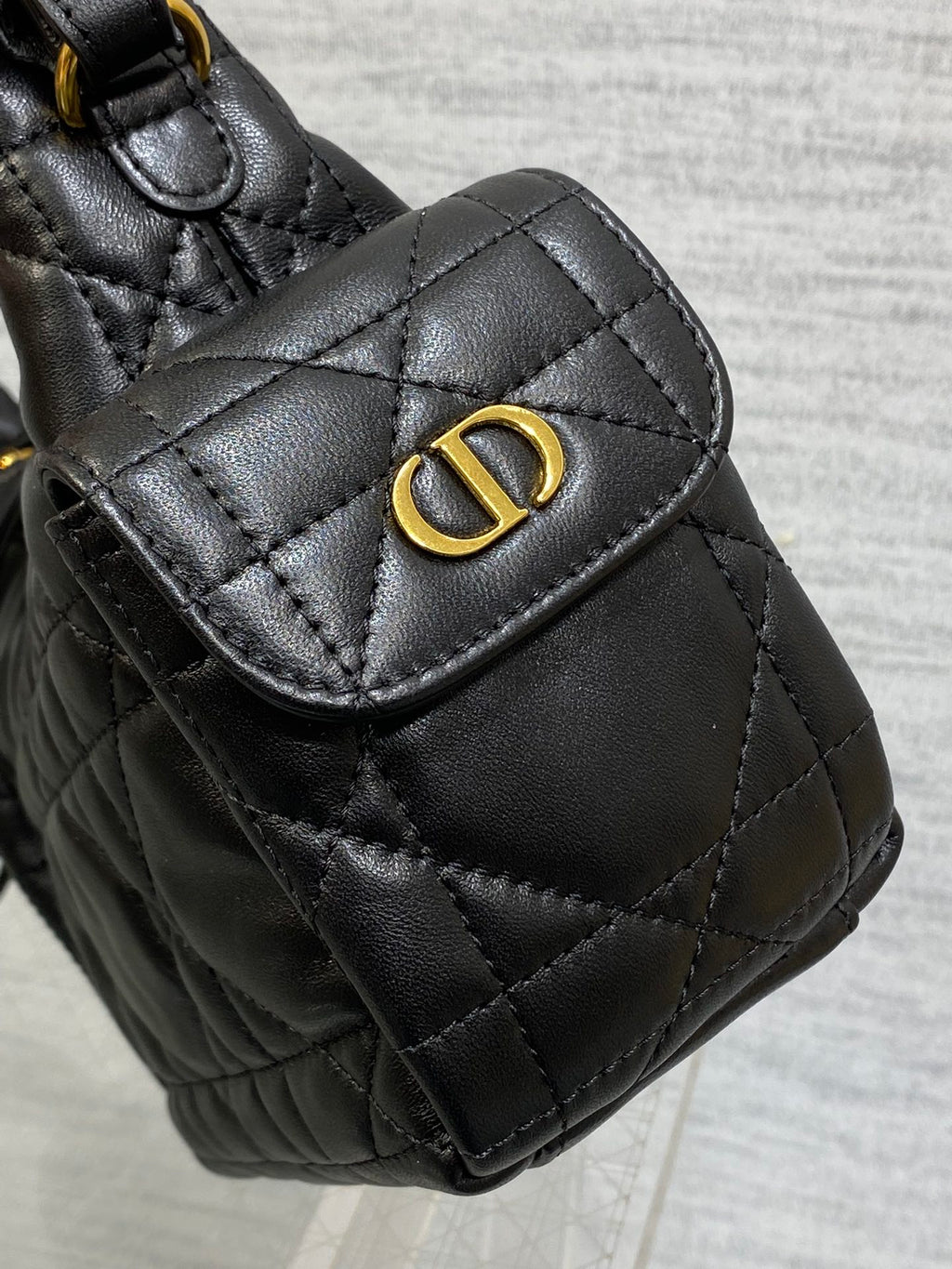 Quilted black leather flap bag with gold Dior-style logo at the front