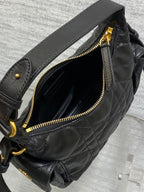 Quilted black leather bag with gold-tone zipper and inner pocket opening