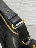 Quilted black leather bag with gold-tone rings and side zipper pull detail