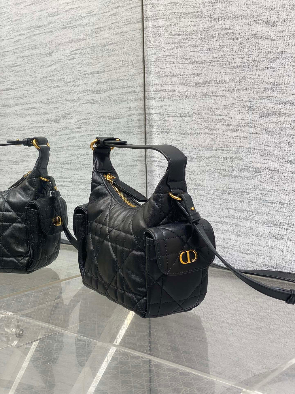 Quilted black leather hobo-style bag with front flap and gold-tone logo hardware