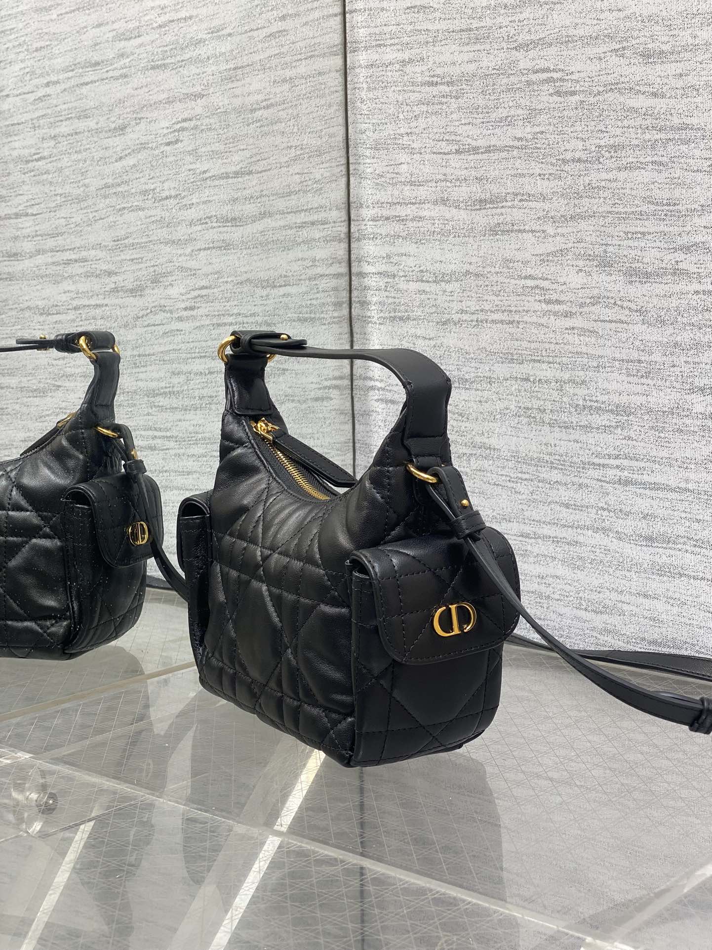 Quilted black leather hobo-style bag with front flap and gold-tone logo hardware