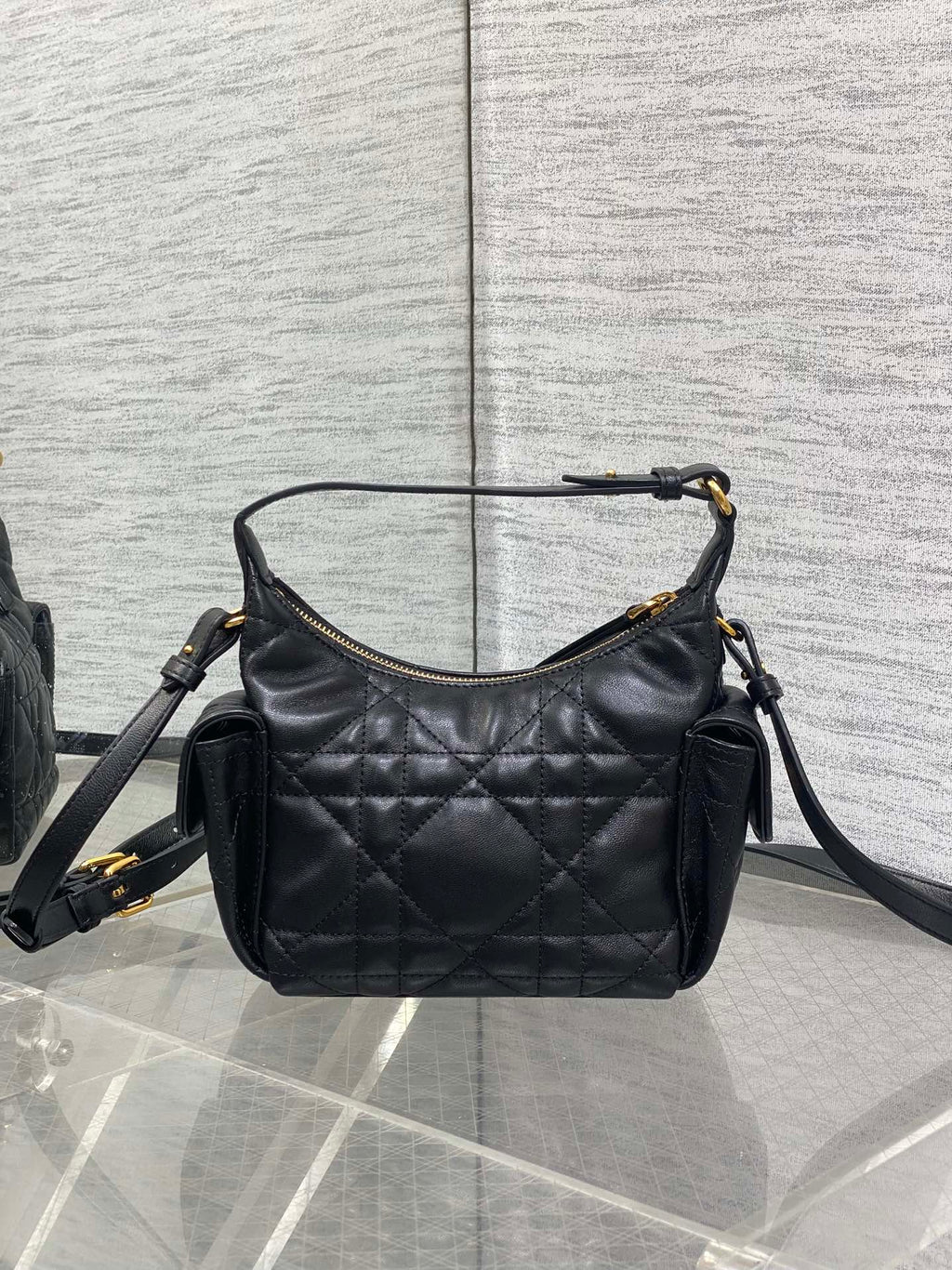 Quilted black leather shoulder bag with gold-tone hardware, side pockets, and strap