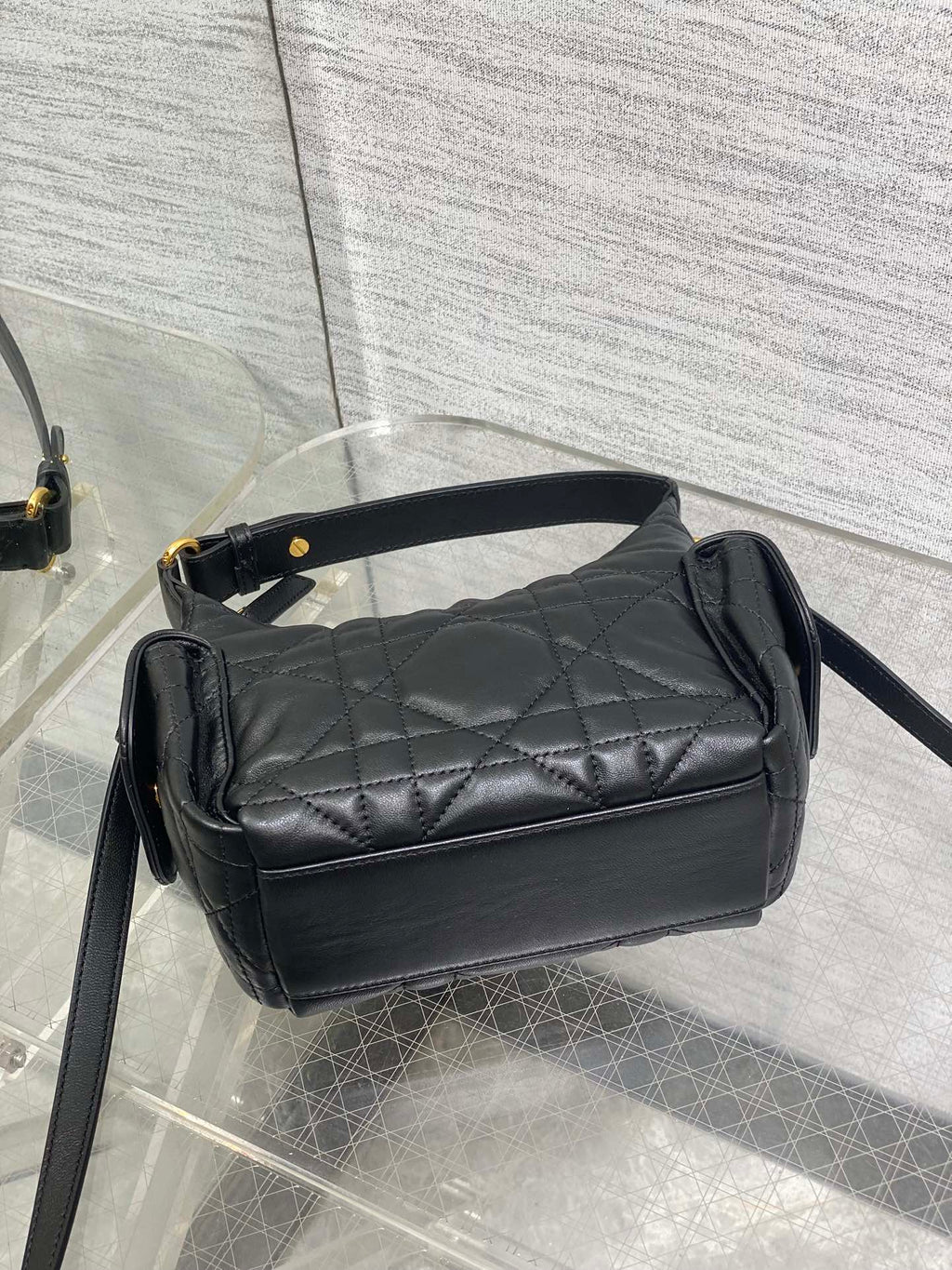 Black quilted shoulder bag with top flap and long crossbody strap, gold accents