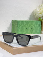 Gucci sunglasses with dark blue frames and gray-tinted square lenses