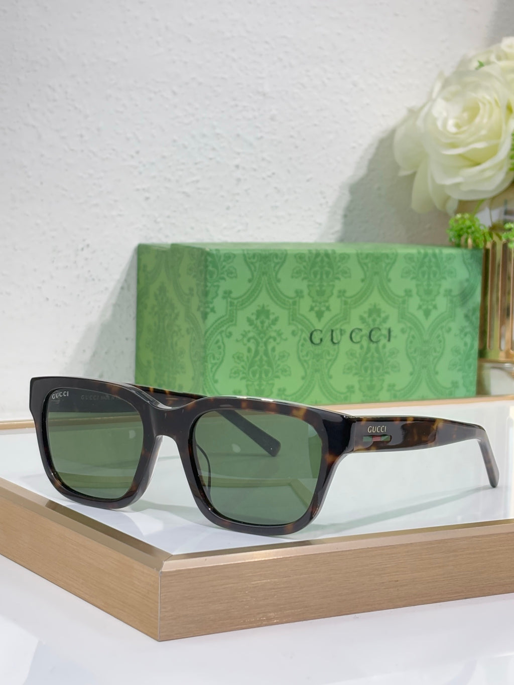 Gucci sunglasses with dark blue frames and green-tinted square lenses