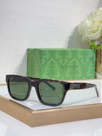 Gucci sunglasses with dark blue frames and green-tinted square lenses