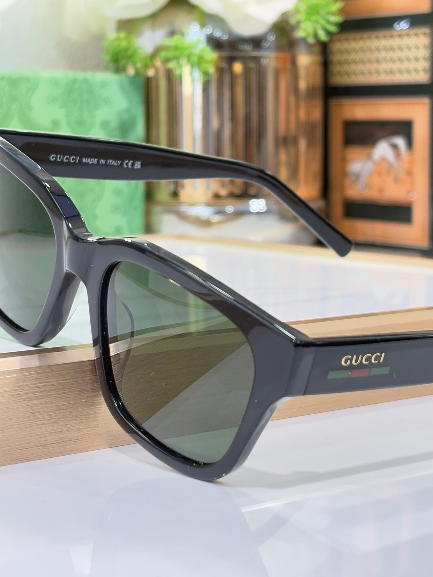 Gucci sunglasses angled view with dark blue frames and green-tinted lenses