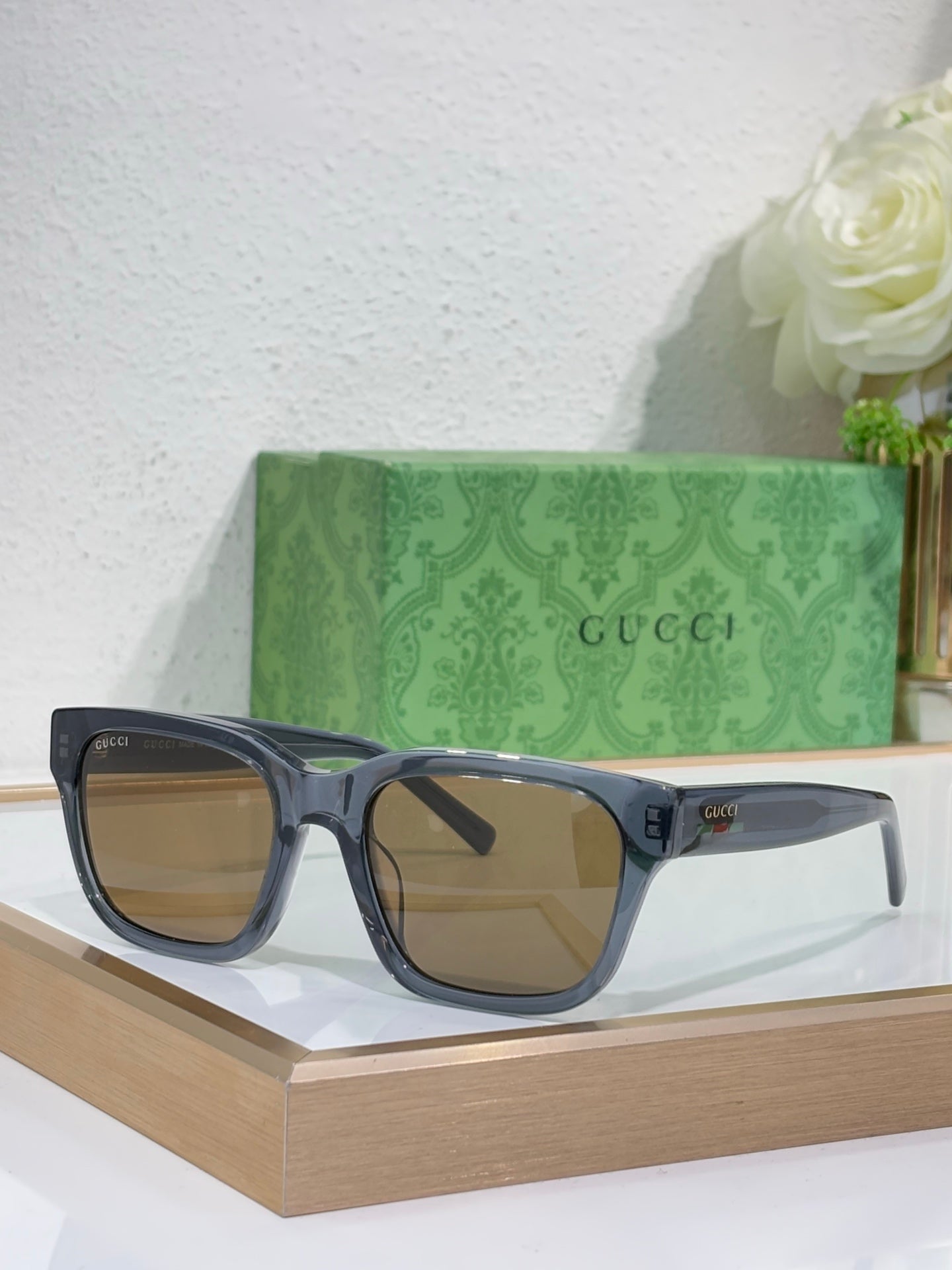 Gucci sunglasses with dark blue frames and amber-brown tinted square lenses