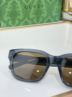 Gucci sunglasses close-up with dark blue frames and brown-tinted lenses