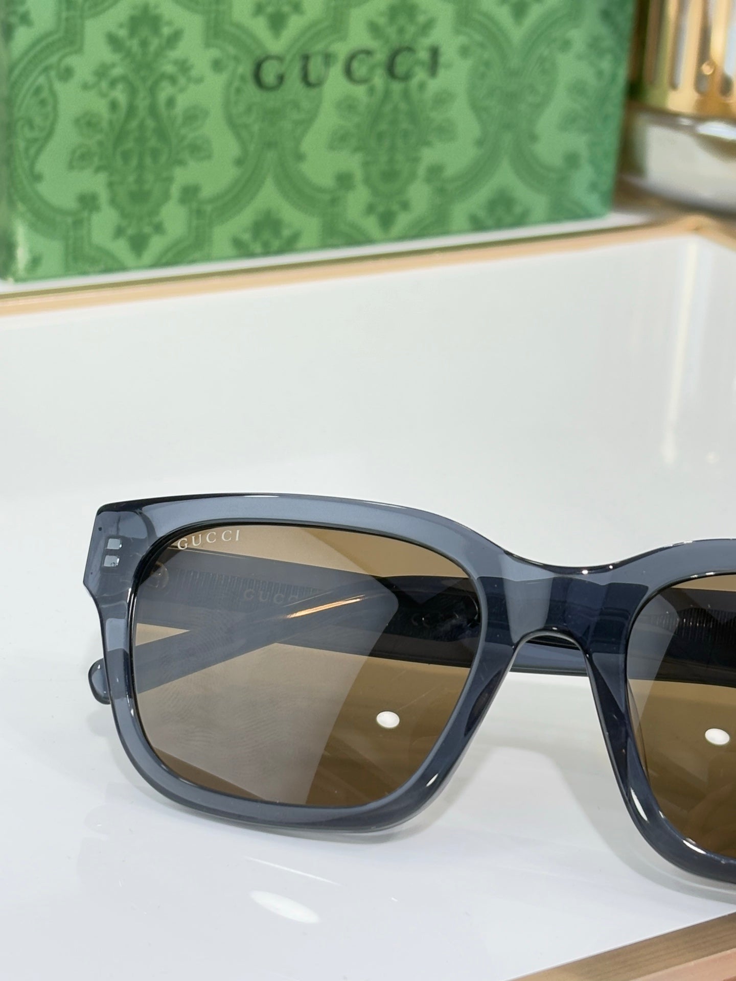 Gucci sunglasses close-up with dark blue frames and brown-tinted lenses