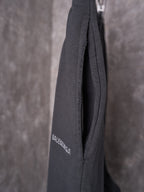 Black shorts back hem closeup with subtle logo print and textured seam.