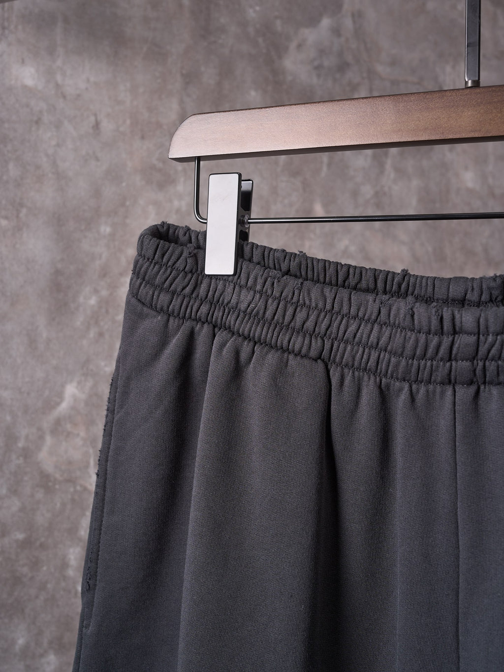 Black shorts front with elastic waistband and hanging tag on a hanger.