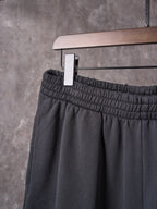 Black shorts front with elastic waistband and hanging tag on a hanger.