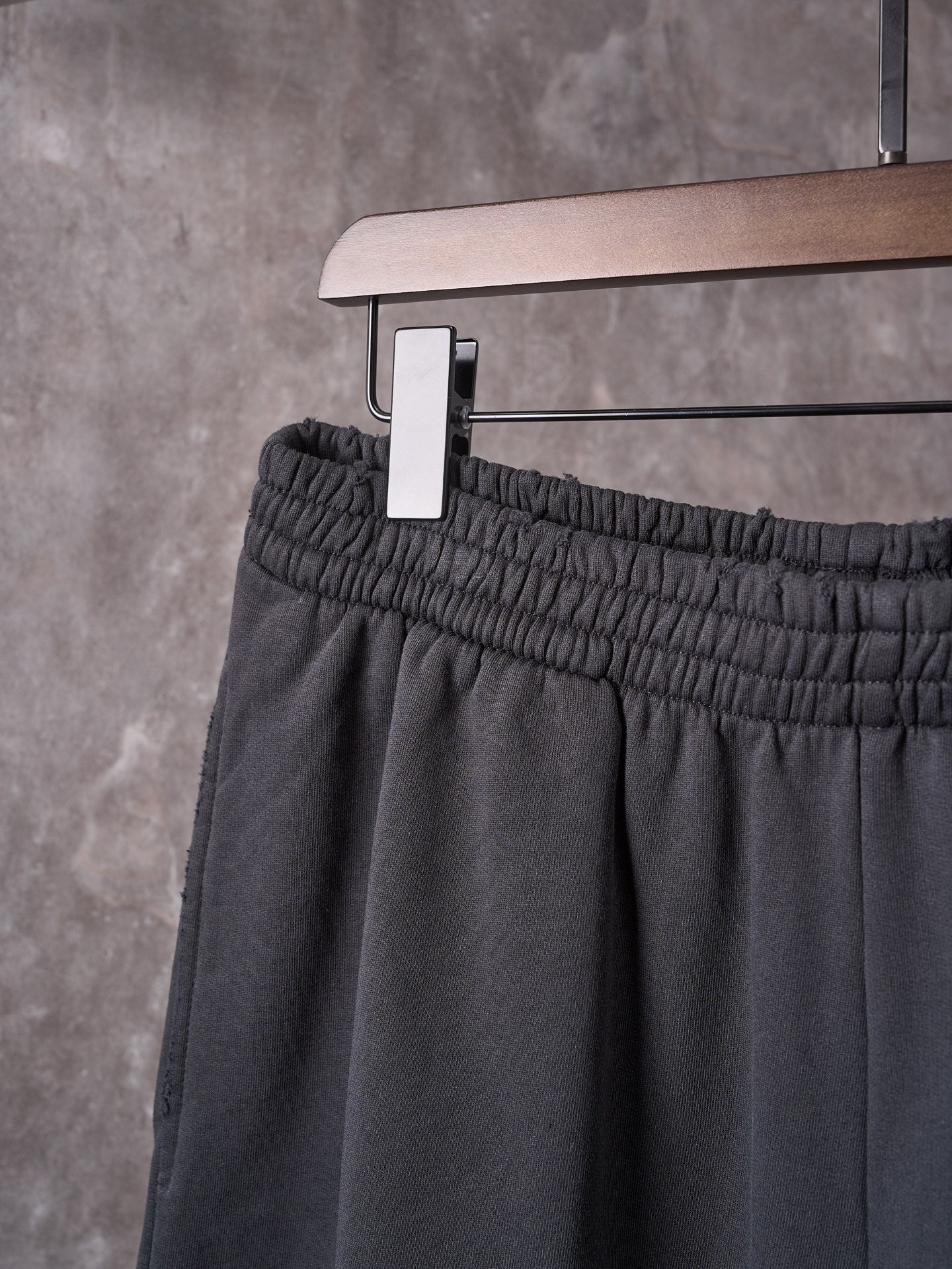 Black shorts front with elastic waistband and hanging tag on a hanger.