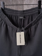 Black shorts waistband with elastic channel, drawstring, and center brand tag.