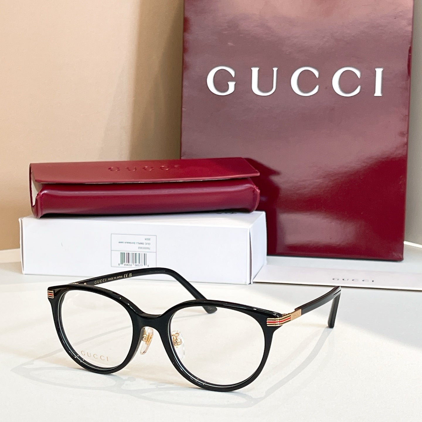 Gucci glasses with black round frames and multicolor striped temples