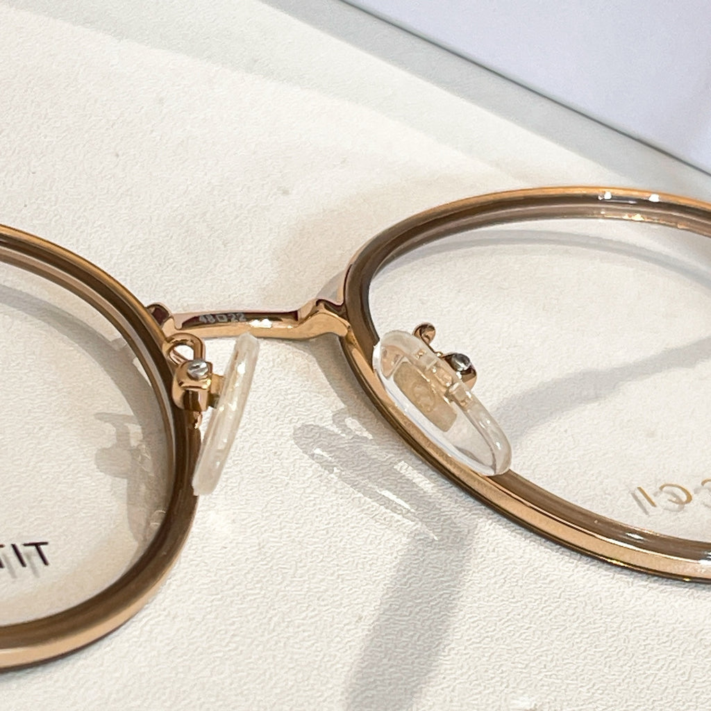 Gucci eyeglass frame close-up, gold round frame with clear lenses