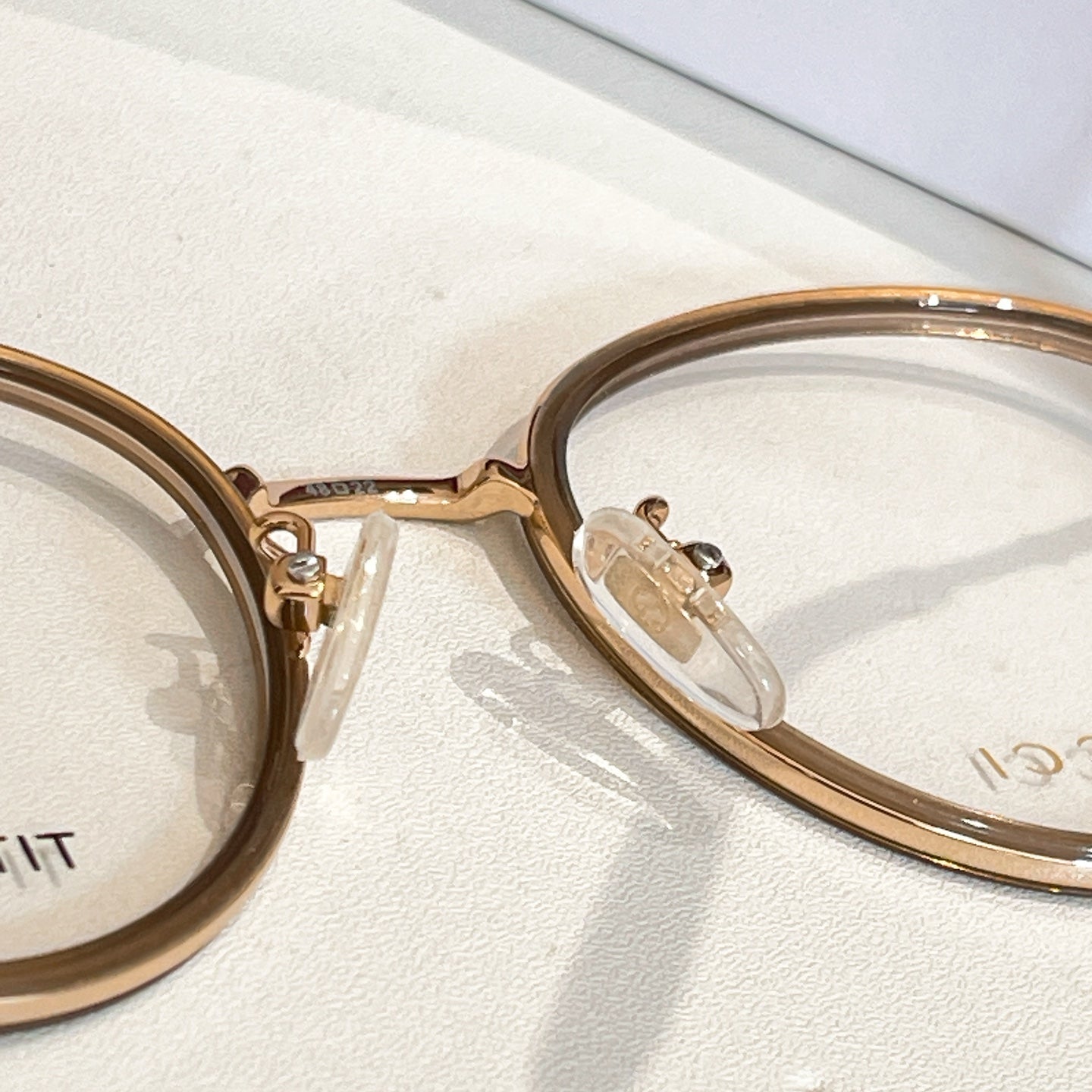 Gucci eyeglass frame close-up, gold round frame with clear lenses