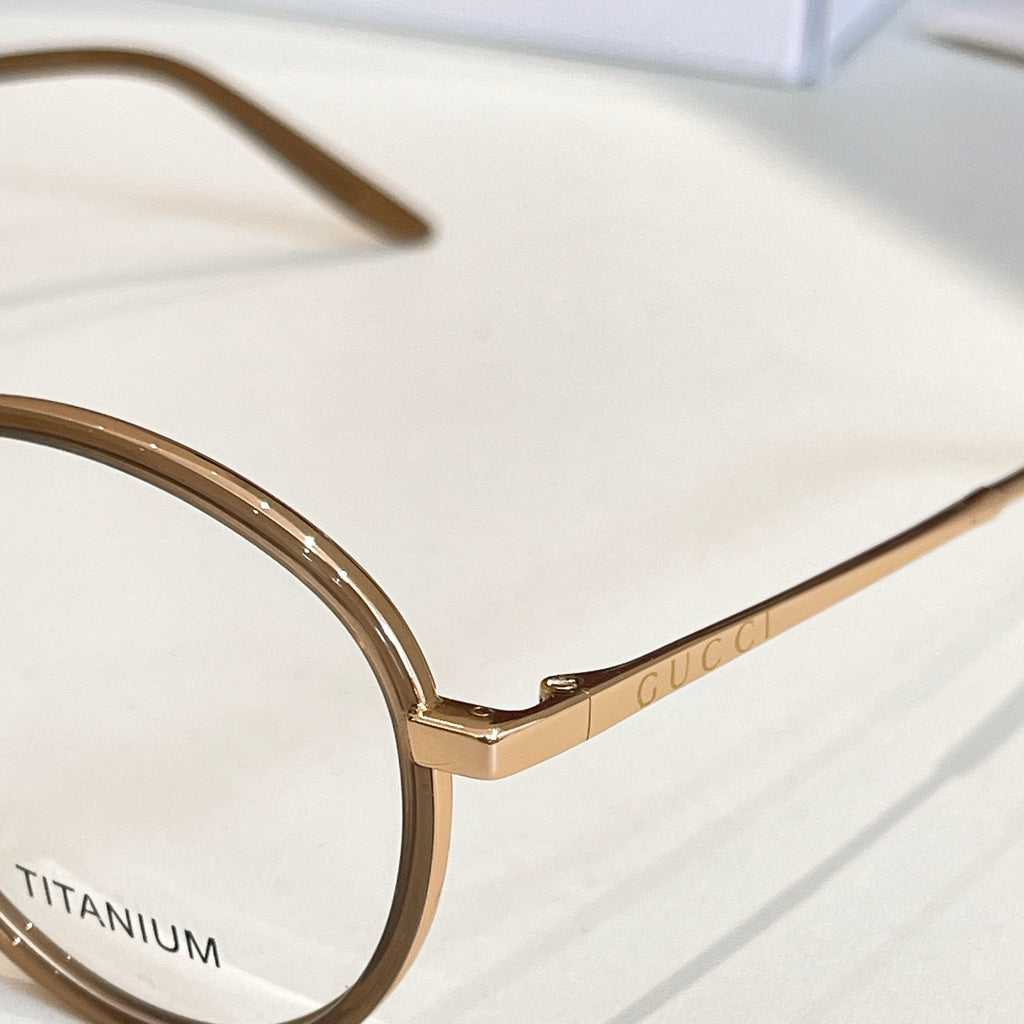 Gucci eyeglass frame close-up, gold rim and clear lenses