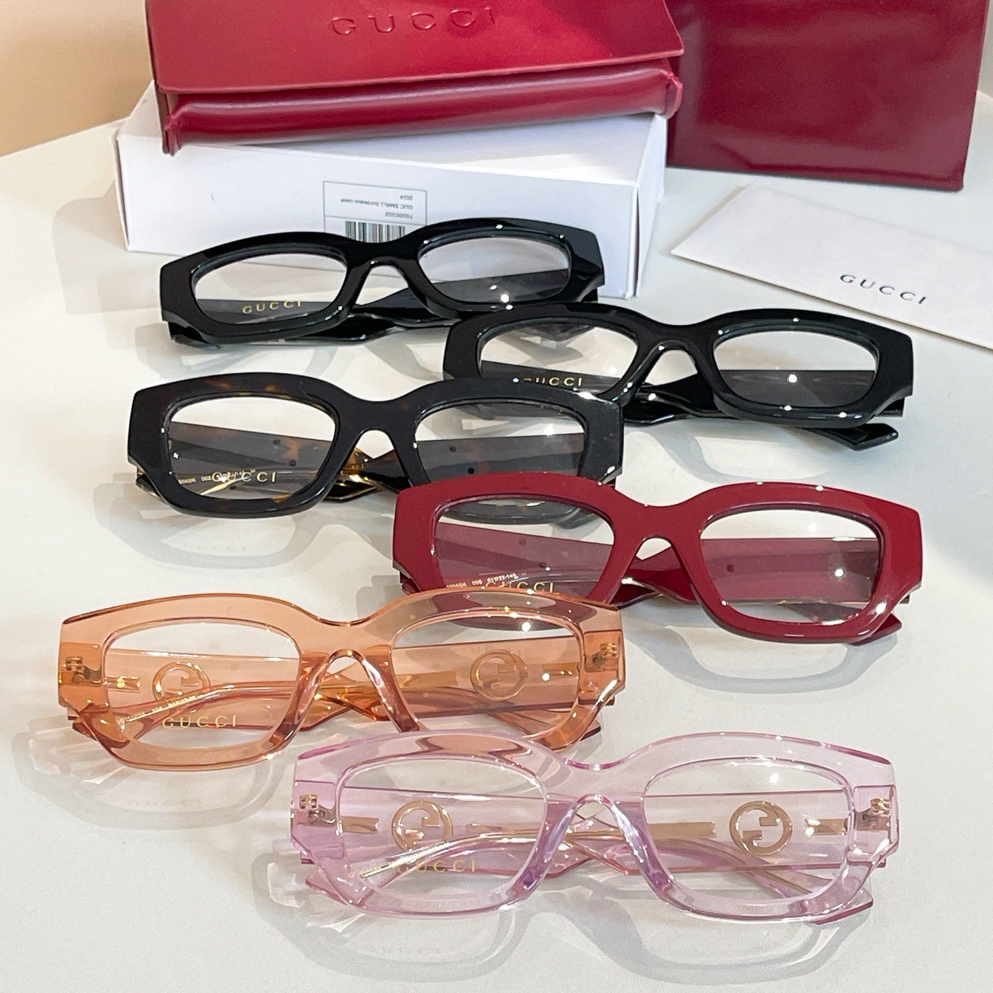 Eyeglasses display with black, red, orange, and pink frames and GG logo details